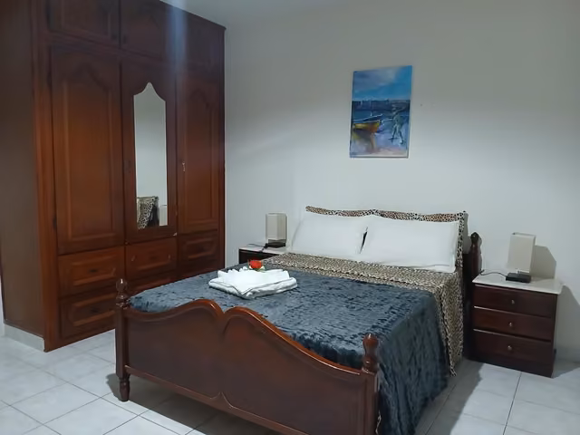 Camera della Romana Guest House a Ostia con letto, comò e specchio