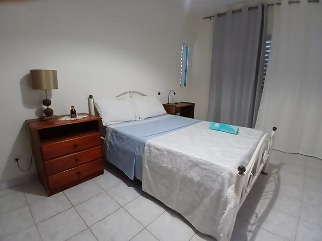 Camera della Romana Guest House a Ostia con letto e cassettiera in legno